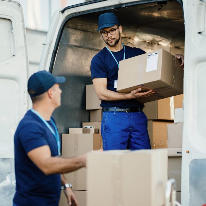 young-worker-loading-cardboard-boxes-delivery-van-communicating-with-his-colleague